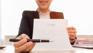 Lender handing someone a pen to sign a contract